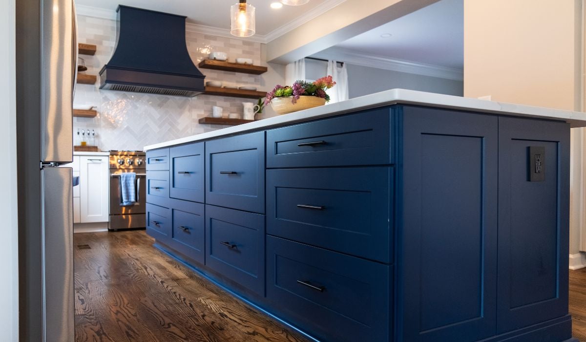 A bold blue kitchen island with dark accent hardware.