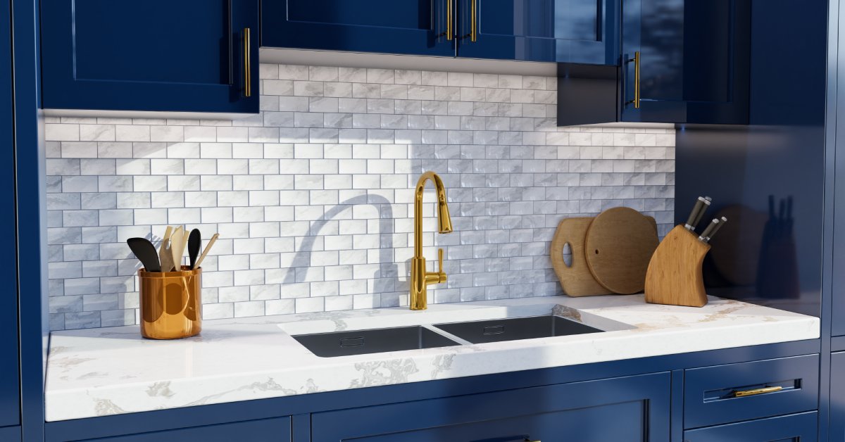 Modern kitchen with navy blue cabinets, gold hardware, marble countertop, subway tile backsplash, and a gold faucet sink.